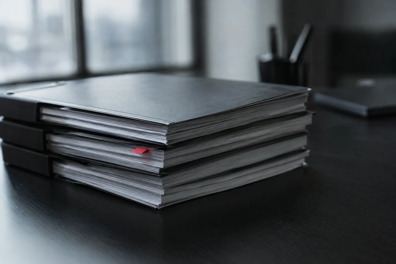 A stack of bound documents with a single red tab